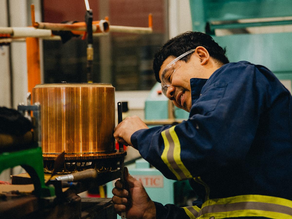 Rogers technician inspecting a copper commutator in the shop