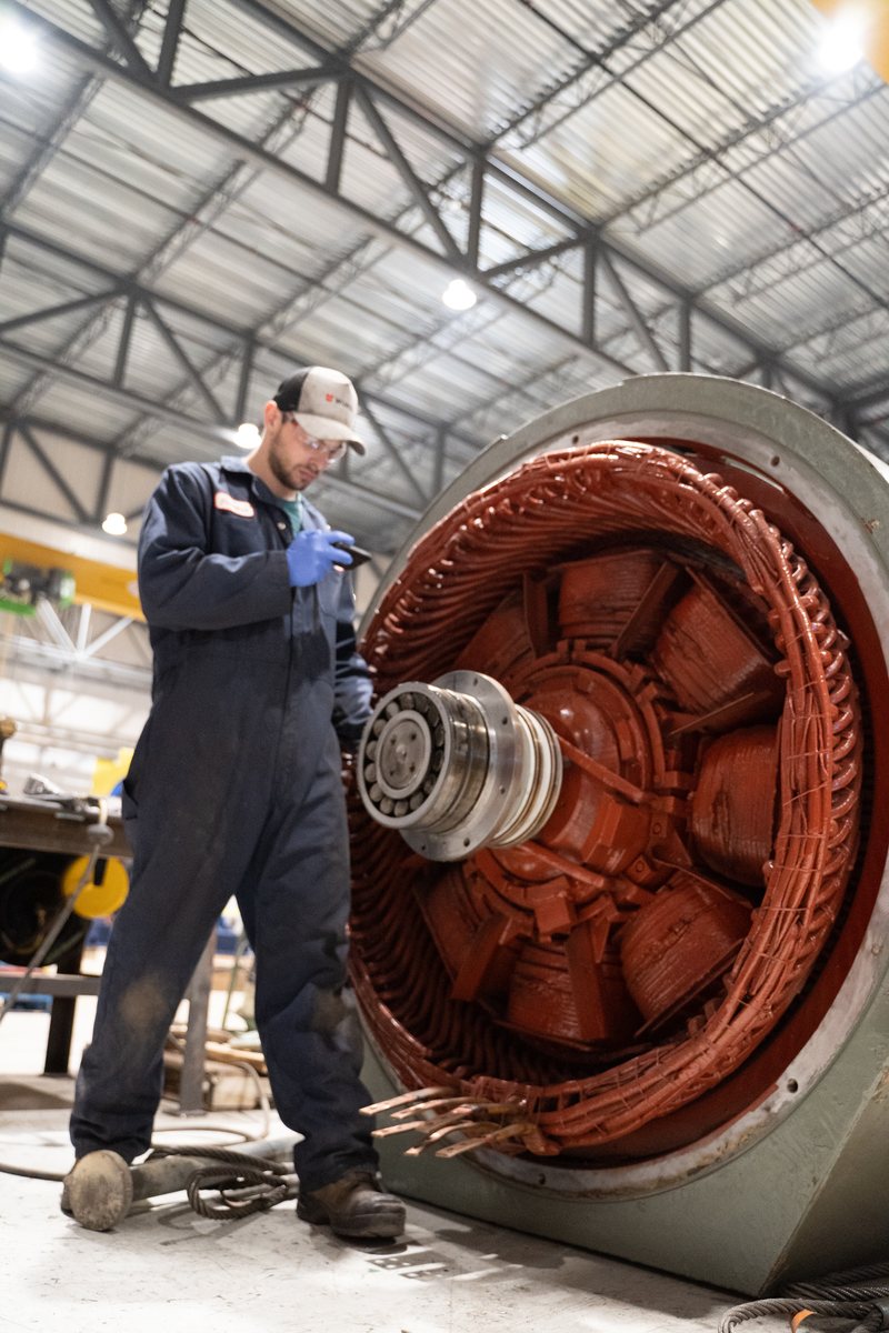 Rogers technician inspecting a large motor stator
