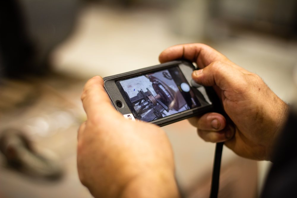Rogers technician documenting a motor into the system with a phone