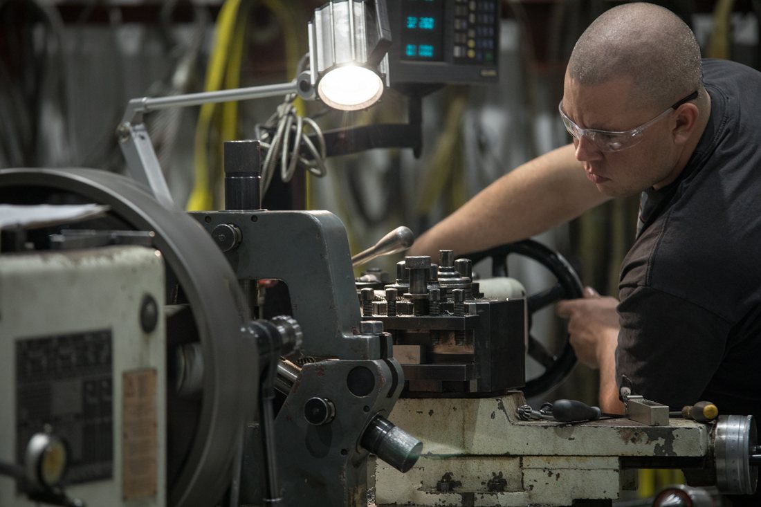 Machinist turning a shaft on the lathe